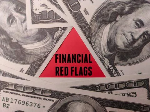 The red triangle with word FINANCIAL RED FLAGS on a hundred dollars Stock Photos