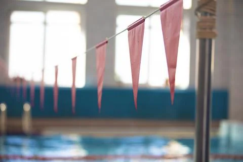 Red triangular flags against the blue water of the swimming pool. 写真素材