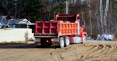 Red truck backing up in reverse before unloading load of dirt Stock Footage 322720578