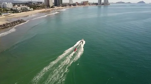 Red tube water sled pulled by a speeding boat near the shore, Mazatlan Vidéo 162811386