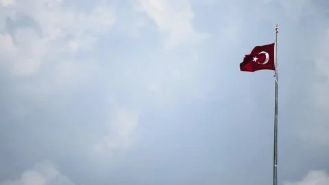 Red Turkish flag fluttering on flagpole against cloudy sky in slow motion x4 Stock Footage 329622696