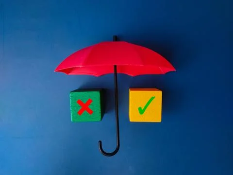 Red umbrella and colored cube with sign wrong and right on blue background. Stock Photos