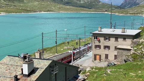 The red UNESCO train leaving the Bernina Pass station Stock Footage 163465196