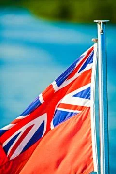 Red with with Union Jack blowing in the wind on the back of a boat Stock Photos