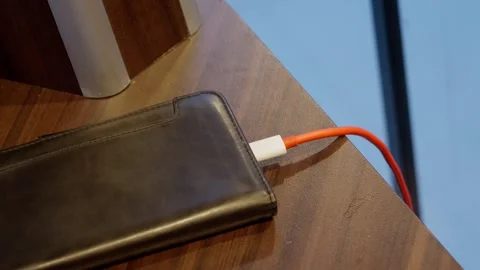 Red usb charging cable removed from cellular phone after charging, close up Stock Footage 259952953