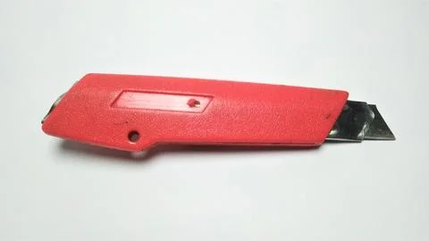 A red utility knife on a plain white background. Stock Photos