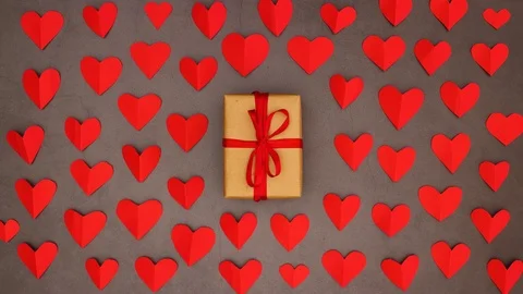Red valentine hearts appear around gift box with red ribbon - Stop motion Stock Footage 123138341