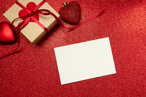 Red valentine's day background with gift and hearts and white sheet for copy Stock Photos