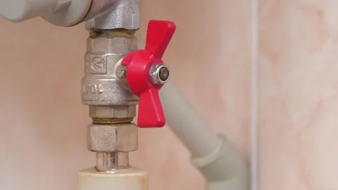 Red valve on cold water pipe to the boiler for heating. Drops of condensation Stock Footage 318418960