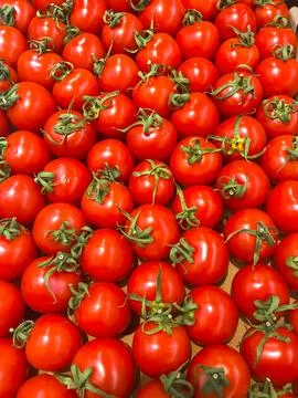 Red vegetable background from ripe cherry tomatoes with place for text. Stock Photos