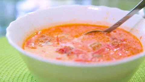 Red vegetable soup borsch of beets with sour cream on a green table. Stock Footage 114308204