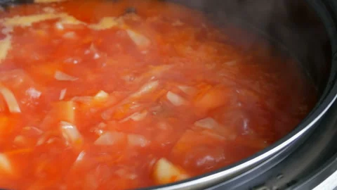Red vegetable soup or tomato soup is cooked in pan and boil close up view Stock Footage 99025161