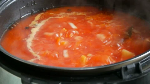 Red vegetable soup or tomato soup is cooked in pan and boil close up view Stock Footage 99026427