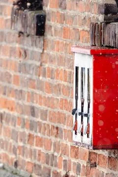 A red vending machine with three compartments sits on a brick wall Stock Photos