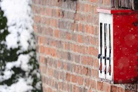 A red vending machine with three compartments is covered in snow Stock Photos