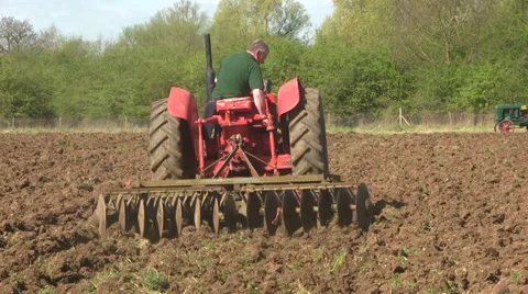 Red vintage tractor pulling a disk harrow. Stock-Footage 37744990