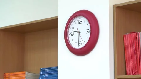 A red wall clock with black hands and a red second hand. Stock Footage 237957739