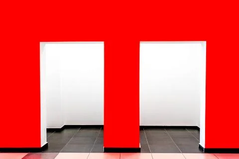 A red wall with two openings inside the building Stock Photos