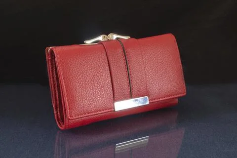 The red wallet is lying on the table with the reflection. Stock Photos