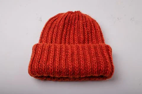 Red warm hat or cap knitted with braid pattern on white background, closeup Stock Photos