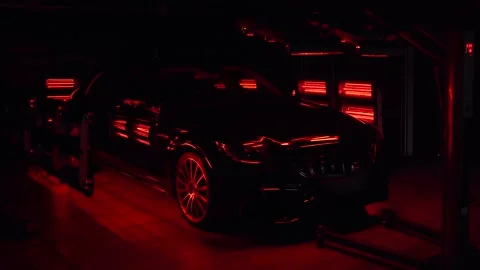 Red warm lamps for curing ceramic polishing standing in back and front of car Stock Footage 131545891