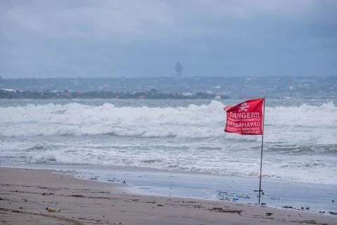 Red warning flag on beach with rough ocean waves Stock-Fotos