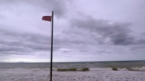 Red warning flag on the beach, windy, stormy day Stock Footage 83857151