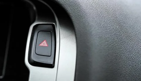 Red warning light triangle button in modern car interior panel, closeup detai 写真素材