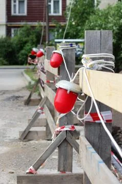 Red warning light which enclosing the ditch, where the repair of water pipes. Stock Photos