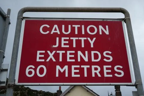 Red Warning Sign 'Caution Jetty Extends 60 Metres' In Conwy, North Wales. Stock Photos