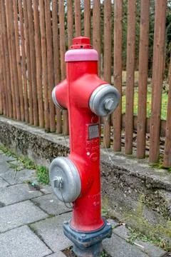 Red water hydrant in the middle of the footpath Stock Photos