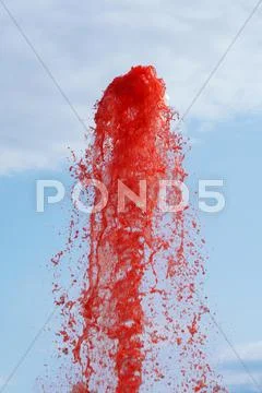 Red water spraying from a fountain Stock Photos