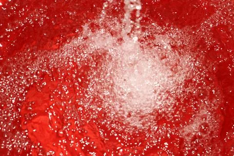 A red water surface with white bubbles. Stock Photos