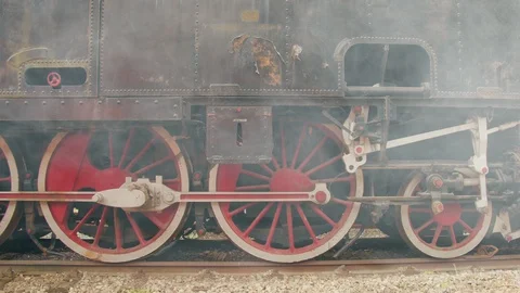 Red wheels of an old steam train, with steam 스톡 동영상 112366043