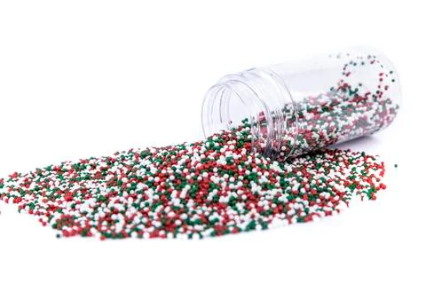 Red white and green colored sprinkles heaping amount spilled from a container Stock Photos