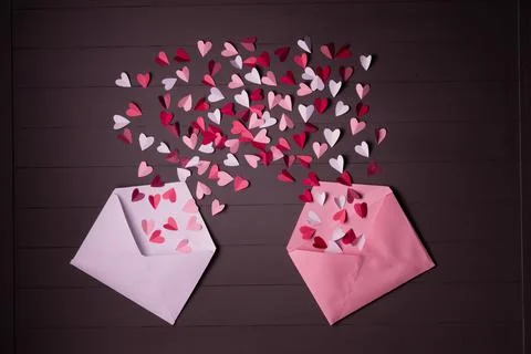 Red, white and pink paper hearts  in open pink and white postal envelopes on Stock Photos