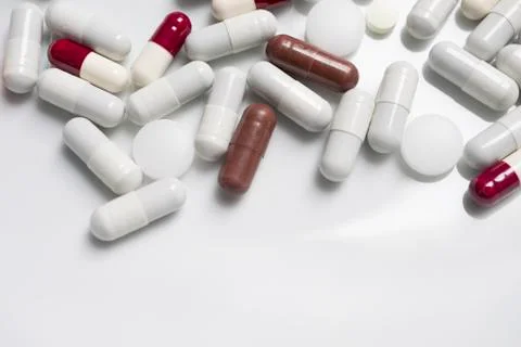 Red, white, brown, orange colored pills in white backround Stock Photos