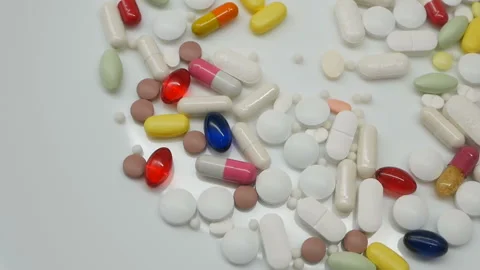 Red, white, colored pills rotating, from the right side, Close up Video stock 85742783