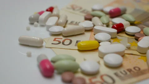 Red, white, colored pills rotating on 50s euro banknotes from the right side Stock Footage 86177300