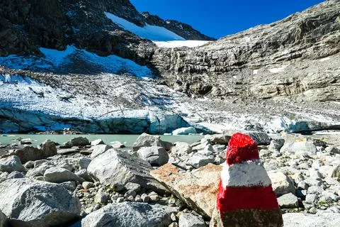 Red white path mark with scenic view on a glacier lake near Hoher Sonnblick.. Stock Photos