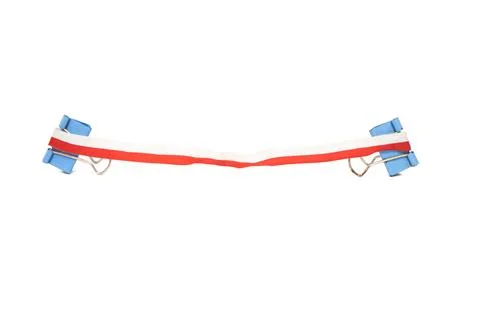 Red, white ribbon is attached using 4 blue paper clips, isolated object on .. Stock Photos