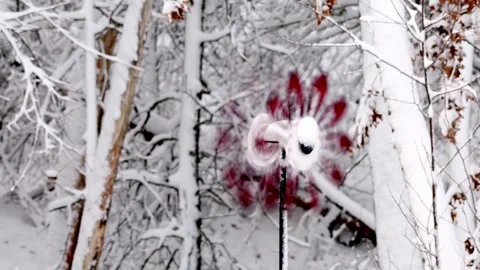 Red Wind Spinner, covered with snow, spins and rotates in winter wind Video stock 331612039