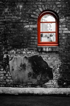 Red window on a brick wall in black and white Stock Photos