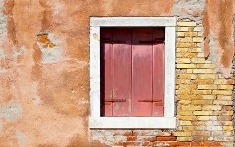 Red window in white frame and ancient decay wall Stock Photos
