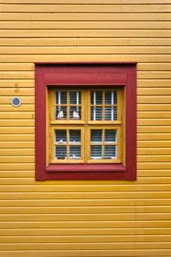 Red window on a yellow wall Stock Photos