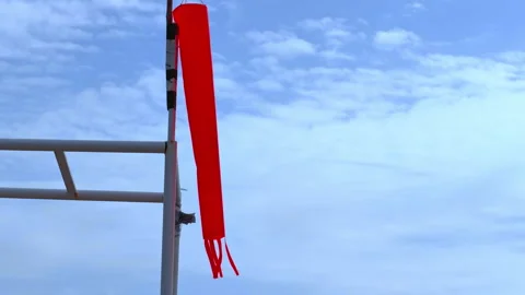 Red windsock hanging on a metal pole against a blue sky Stock-Footage 342520385