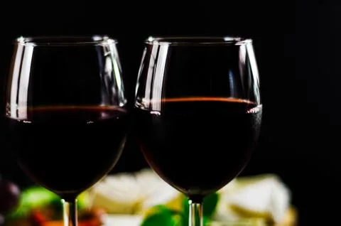 Red wine and set of different cheeses on a wooden board, delicious snack Stock Photos