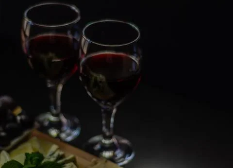 Red wine and set of different cheeses on a wooden board, delicious snack Stock Photos