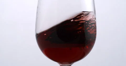 Red wine is being swirled in transparent glass for quality check in wine cellar Stock Footage 268473080