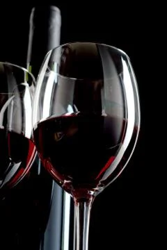 Red wine in bottle and two wineglasses on black background Stock Photos